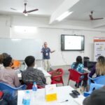 A founder mapping and testing startup assumptions on a board, as taught at Parul University