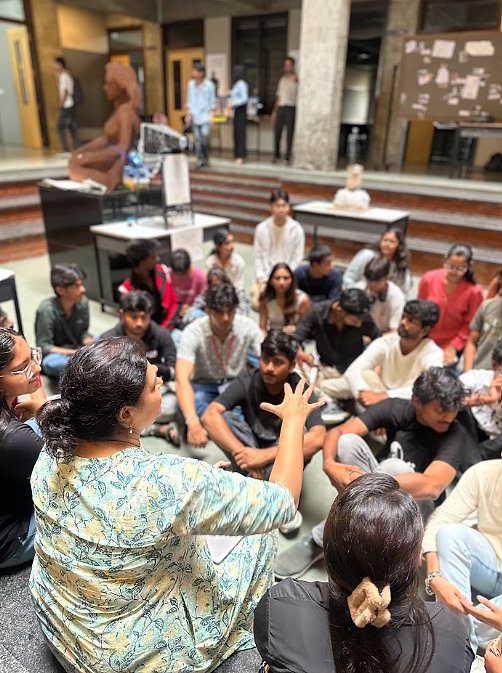 Faculty leading a seated crit circle in the atrium